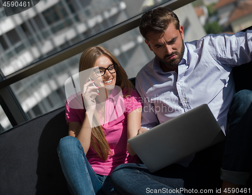 Image of couple relaxing at  home using laptop computer