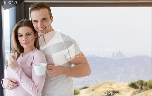 Image of young couple enjoying morning coffee by the window