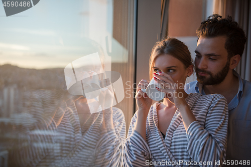 Image of young couple enjoying evening coffee by the window