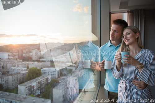 Image of young couple enjoying evening coffee by the window