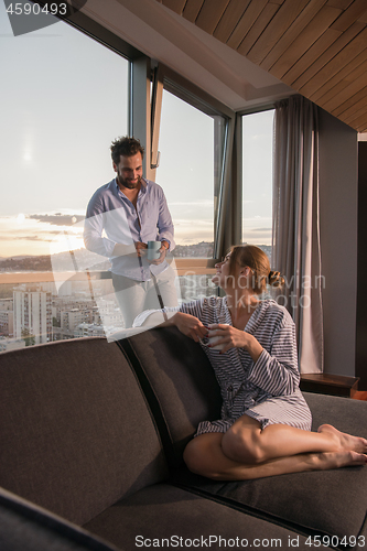 Image of young couple enjoying evening coffee by the window