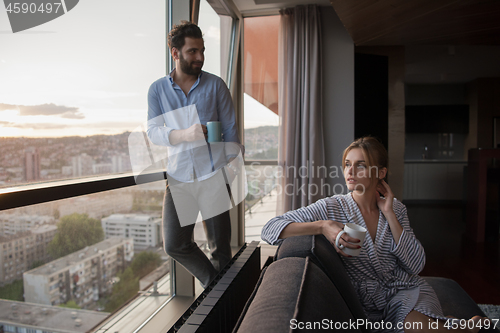 Image of young couple enjoying evening coffee by the window