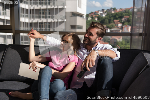 Image of Young couple watching television