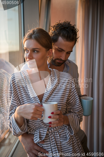 Image of young couple enjoying evening coffee by the window