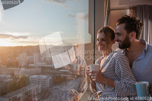 Image of young couple enjoying evening coffee by the window