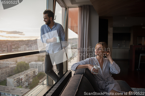 Image of young couple enjoying evening coffee by the window