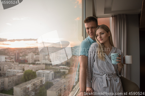 Image of young couple enjoying evening coffee by the window