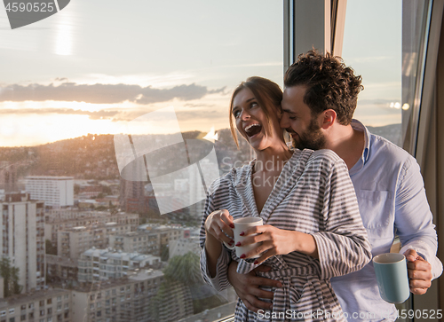 Image of young couple enjoying evening coffee by the window