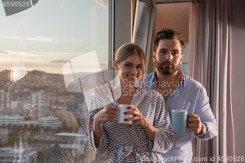 Image of young couple enjoying evening coffee by the window