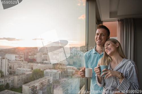 Image of young couple enjoying evening coffee by the window