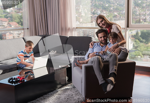 Image of happy young couple spending time with kids