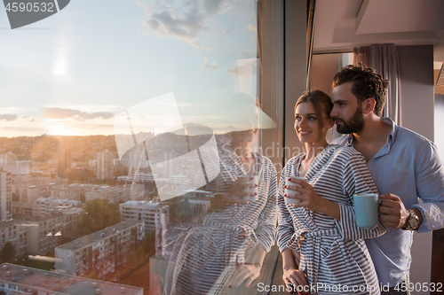 Image of young couple enjoying evening coffee by the window