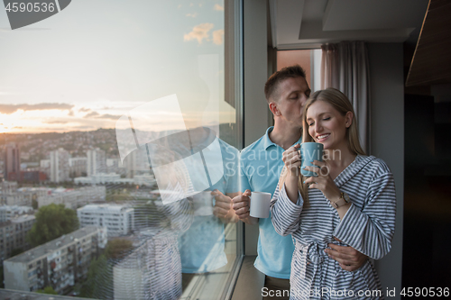 Image of young couple enjoying evening coffee by the window