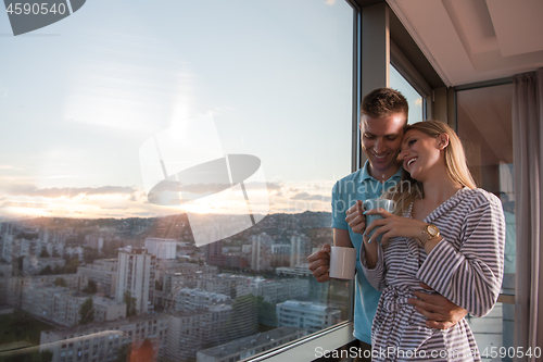 Image of young couple enjoying evening coffee by the window