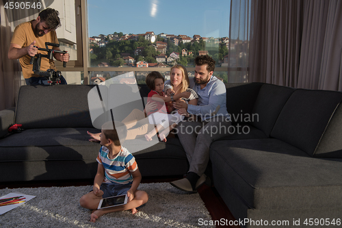 Image of happy young couple spending time with kids at home