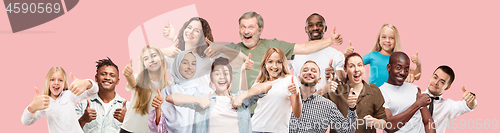 Image of The happy business women and men standing and smiling against pink background.