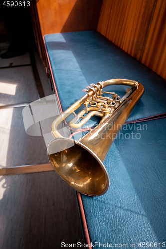 Image of Blowing brass wind instrument on the bench