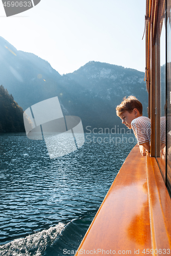 Image of Konigssee lake, Bavaria - August 19, 2018: Unknown boy looking at green water of Konigssee, known as Germany deepest and cleanest lake