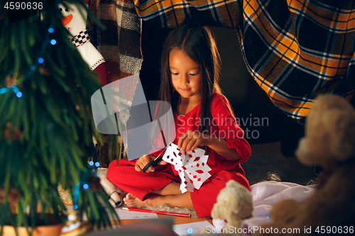 Image of Beautiful girl holding her hands with snowflakes from the paper