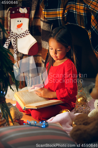 Image of happy girl reading a book in the winter