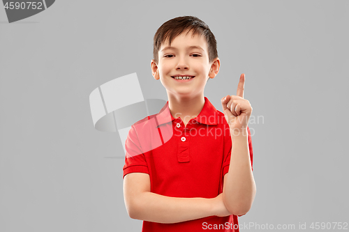 Image of happy little boy in red t-shirt pointing finger up