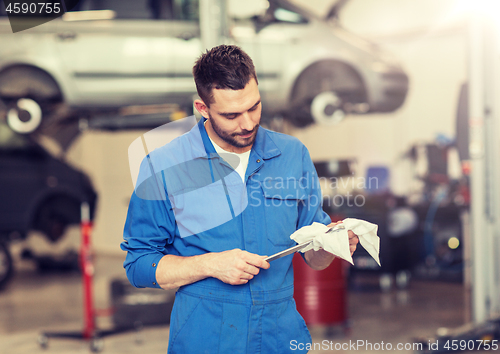 Image of auto mechanic or smith with wrench at car workshop