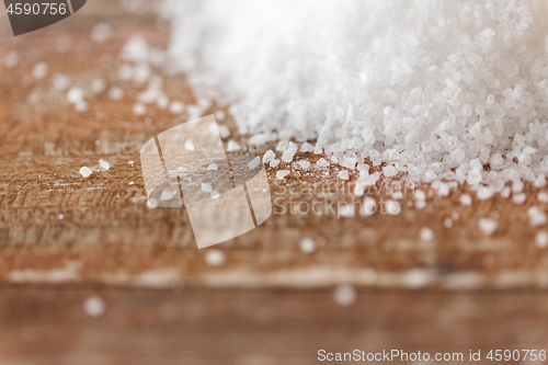 Image of close up of white salt heap on wooden table