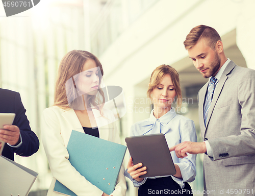 Image of business team with tablet pc and folders at office