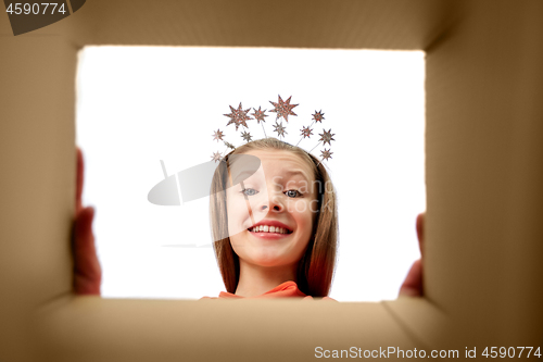 Image of happy girl in tiara looking into open gift box