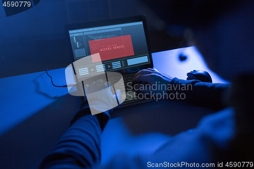 Image of hands of hacker with access denied message laptop