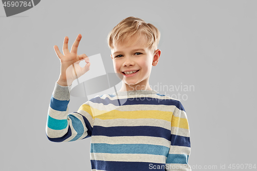 Image of boy in striped pullover showing ok hand sign