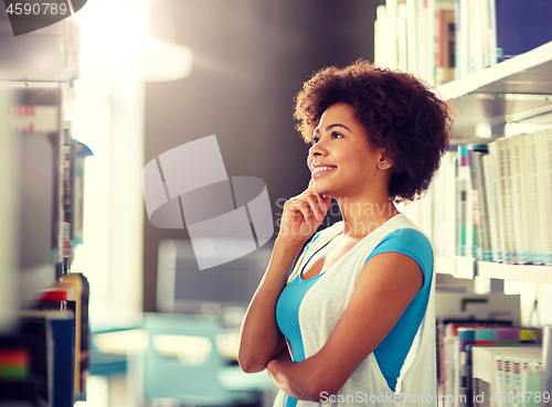 Image of african student girl looking for book at library