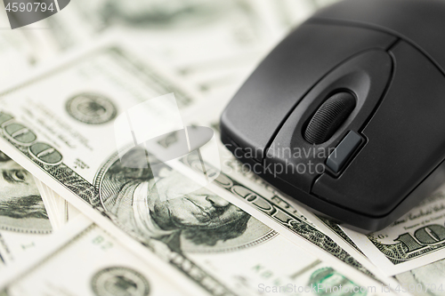 Image of close up of computer mouse on us dollar money