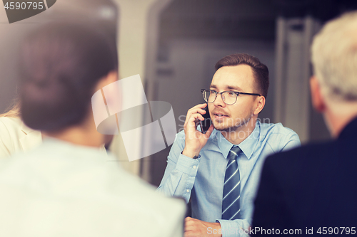 Image of businessman calling on smartphone at office