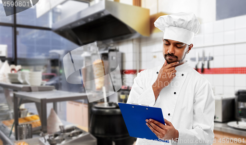 Image of indian chef with menu on clipboard at kebab shop