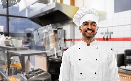 Image of happy male indian chef in toque at kebab shop