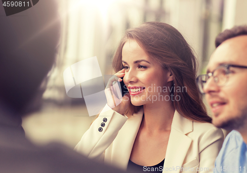 Image of businesswoman calling on smartphone at office