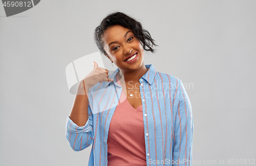 Image of happy african american woman showing thumbs up