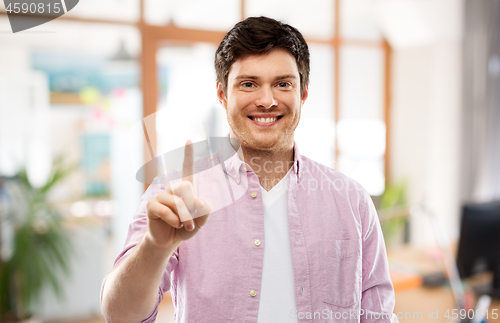 Image of young man showing one finger over office room