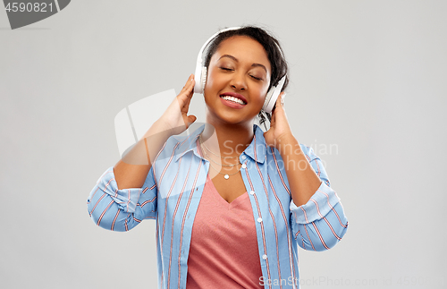 Image of african woman in headphones listening to music