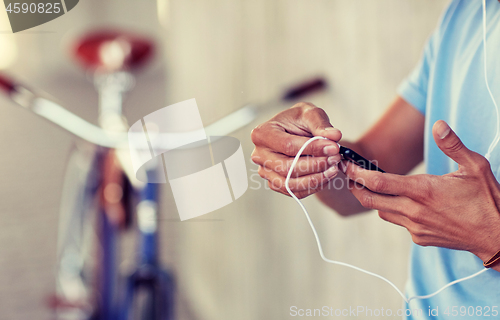 Image of man with earphones and smartphone listening music