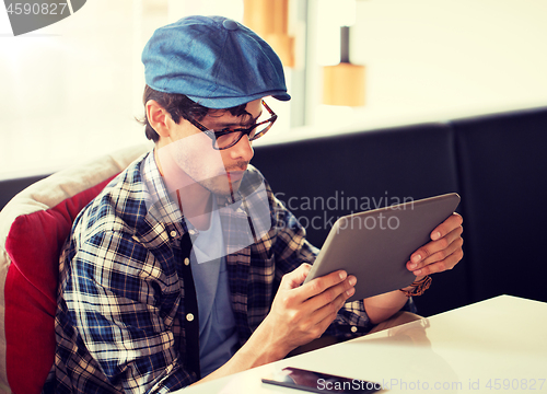 Image of man with tablet pc sitting at cafe table