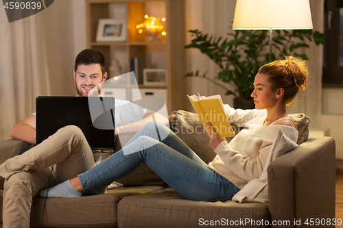 Image of couple with laptop computer and book at home