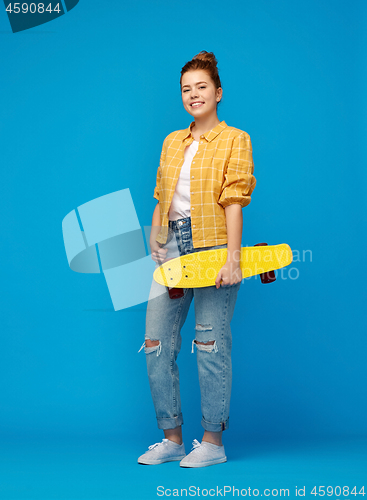 Image of red haired teenage girl with short skateboard