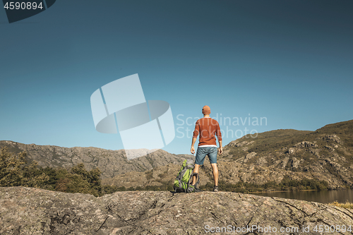 Image of Man hiking near a beautiful lake