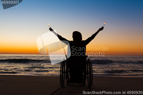 Image of Handicapped woman holding fire sparklers