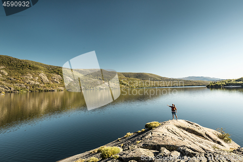 Image of Man hiking near a beautiful lake