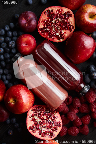 Image of Mix of fresh red and black fruits. With botteled fresh juices