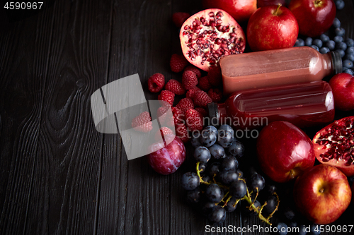 Image of Mix of fresh red and black fruits. With botteled fresh juices