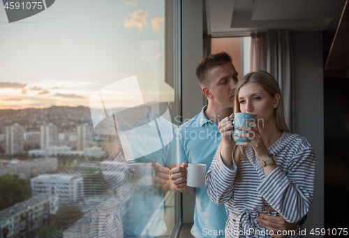 Image of young couple enjoying evening coffee by the window